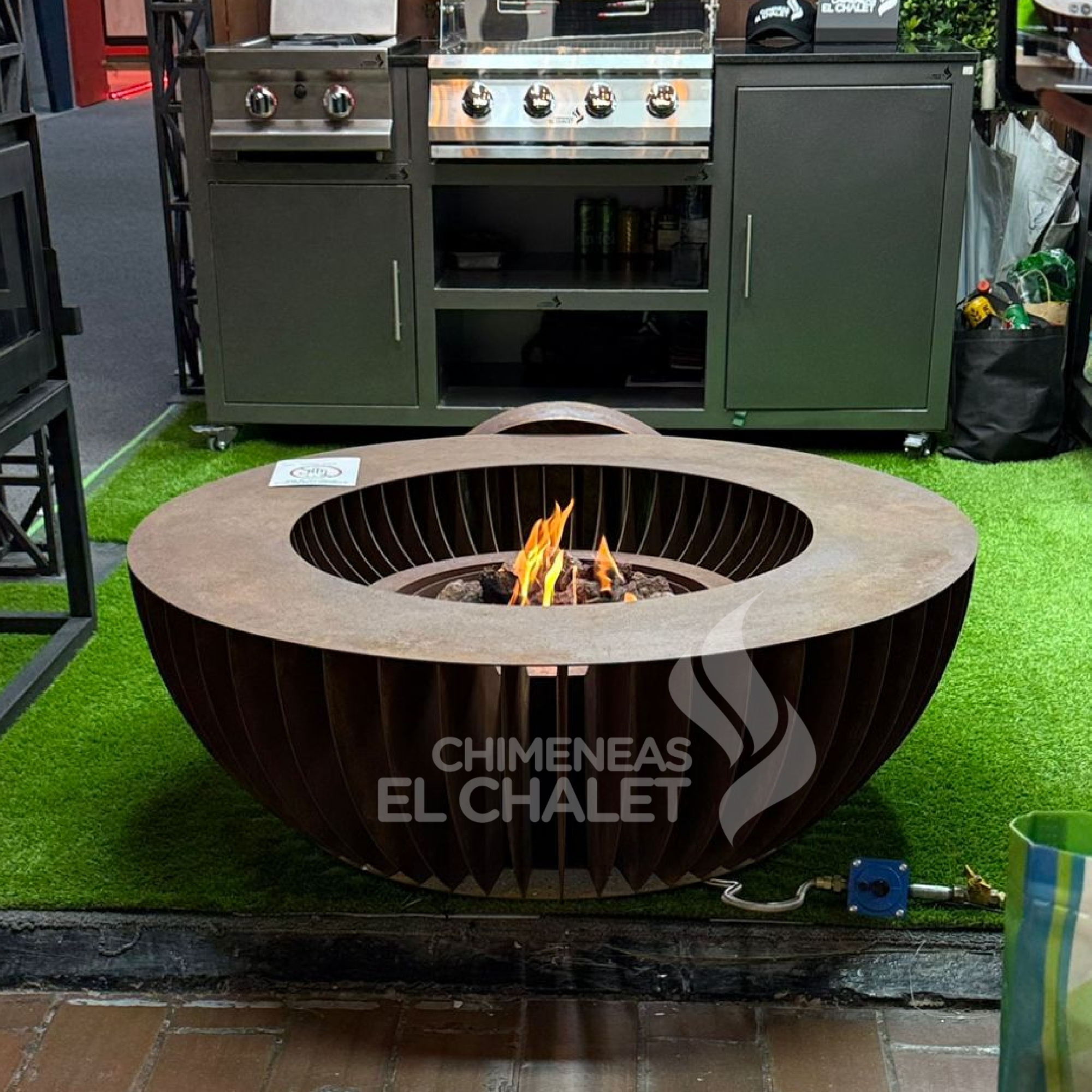 Fuego en fogata metálica moderna para exteriores.